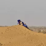 Ein Beduine ruht auf einer Düne